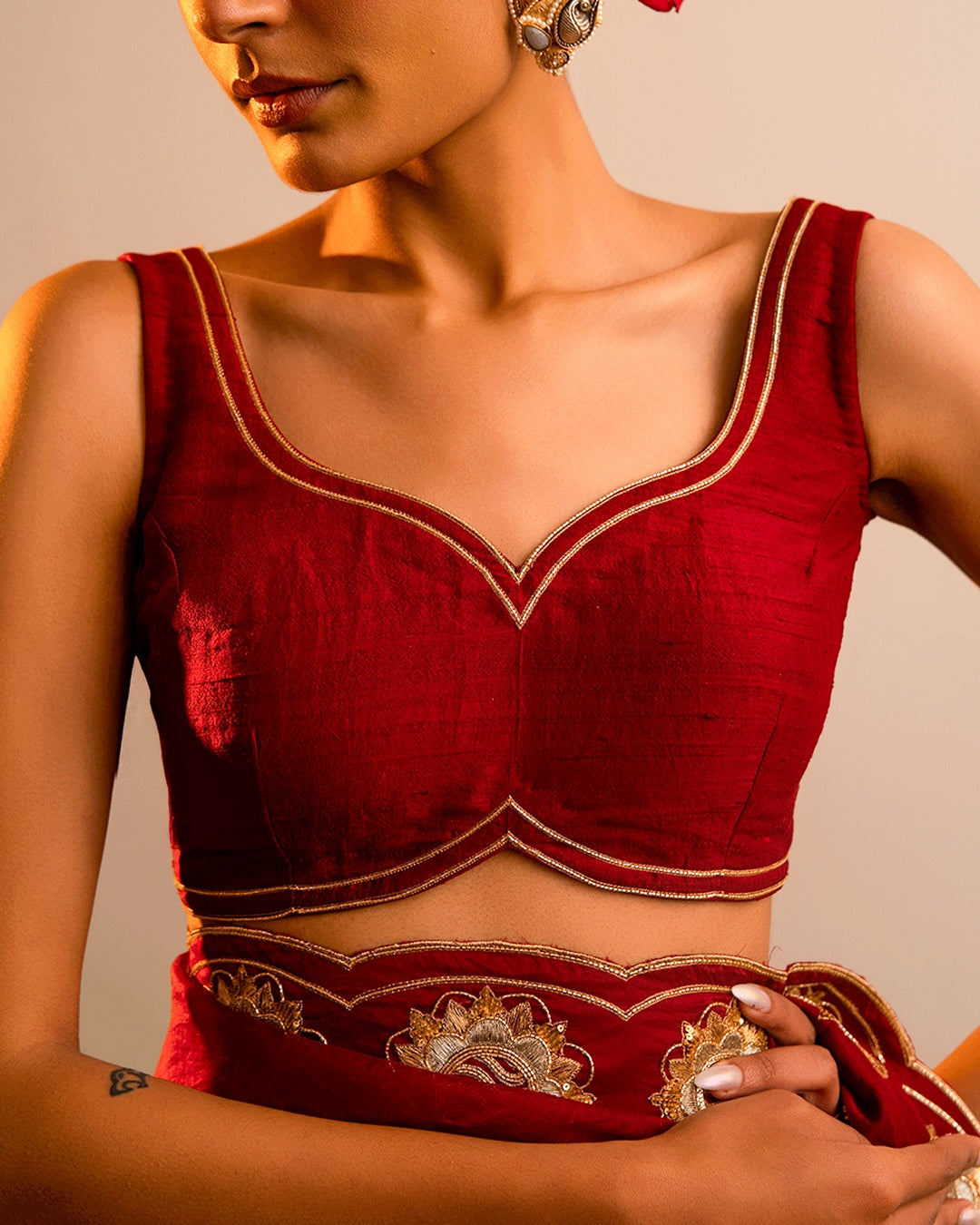 Red embroidered blouse worn by a person against a neutral background